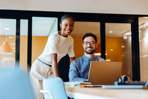 Smiling colleagues working together in bright office environment