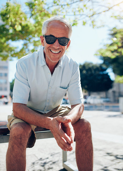 Smiling senior tourist sitting outdoors in the city