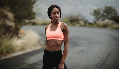 Young woman athlete walking on road
