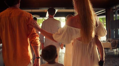 Joyful family arriving for dinner at a tropical restaurant