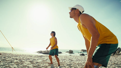 Wide angle handheld action shot of professional male Australian beach volleyball players