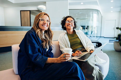Two women working in a cozy office lounge