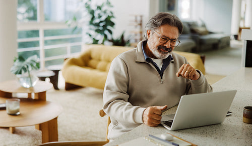 Senior man uses a laptop at home in retirement