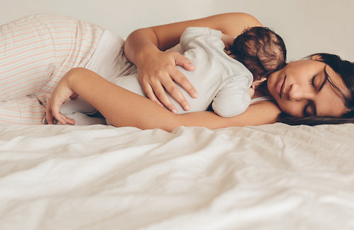 Young woman cuddling her newborn baby boy