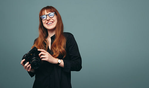Happy young photographer smiling cheerfully in a studio