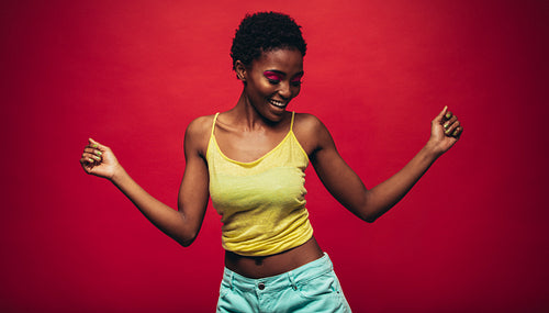 African woman dancing over red background