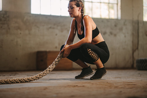 Woman taking rest after battle rope workout