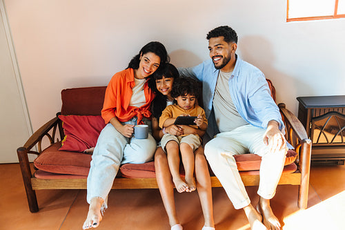 Happy Latin American family enjoying togetherness on a cozy sofa at home