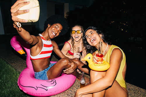 Friends at a pool party selfie night