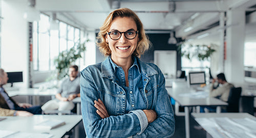 Happy female executive with arms crossed