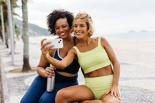 Beach workout vibes: Fit women taking a selfie on the beach promenade