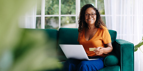Electronic banking for senior citizens: Elderly woman using her credit card online