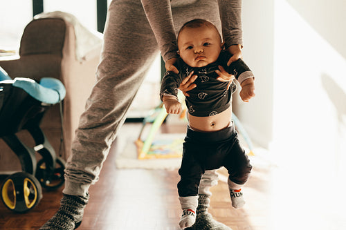 Mother making her baby walk