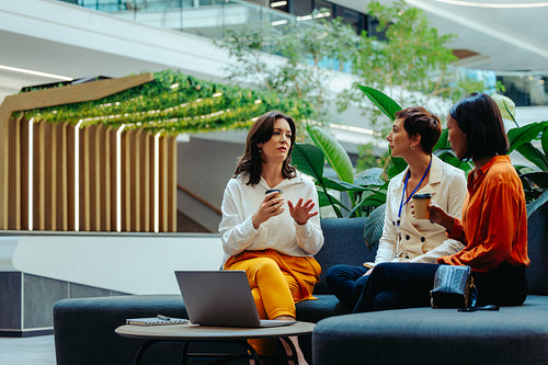 Female executive consulting with employees in modern office