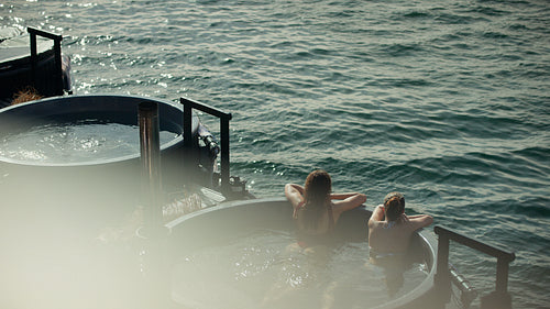 Spa time finds women soaking together by the sea