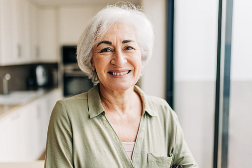 Senior woman smiling at the camera inside her home