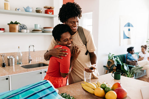 Happy family's morning routine: Mother and son in kitchen embracing, getting ready for the day