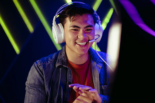 Male gamer looking at his pc screen with a smile, pleased with his performance