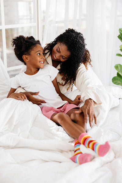 Loving mother and daughter enjoying time together in bed
