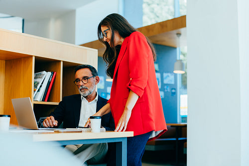Senior executives reviewing project details in a professional office setting