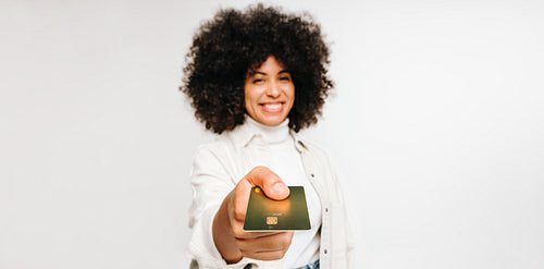 Happy young woman paying with a credit card