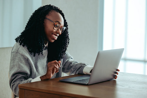 African-American business woman working on a laptop at a desk with a smile