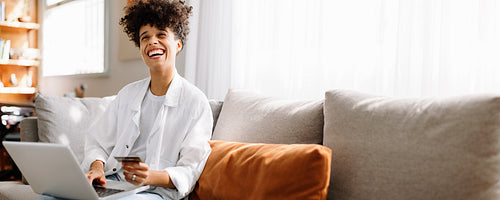 Carefree young woman spoiling herself with an online purchase