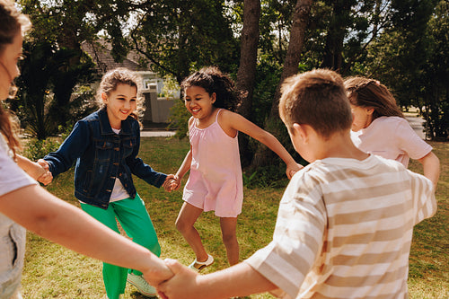 Children playing outdoors happily together in a sunny park