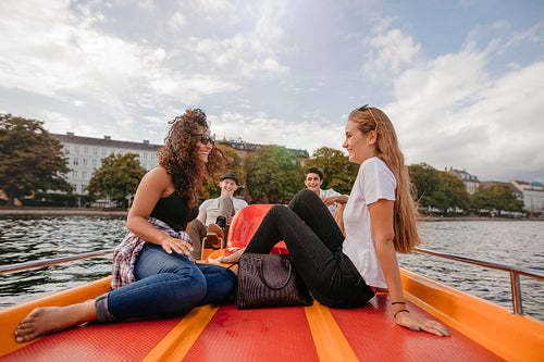 Teenage friends relaxing on pedal boat