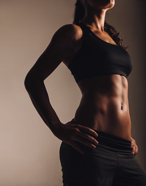 Muscular young woman posing in sportswear