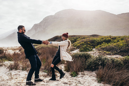 Beautiful couple dancing along the beach on winter day