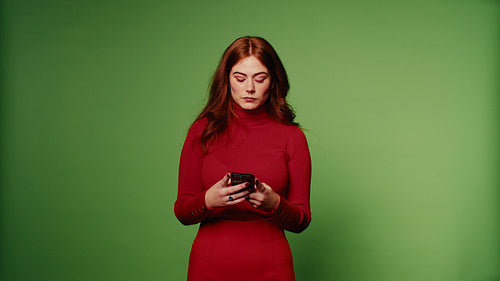 A young woman looks serious while using her phone