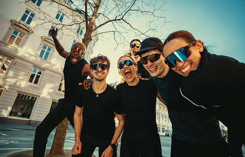 Running friends posing together outdoors in the city before a group workout