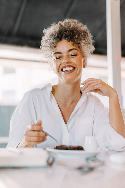 Carefree mature woman having lunch in a cafe