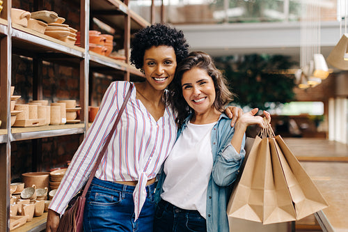 Happy female customers smiling in a ceramic store