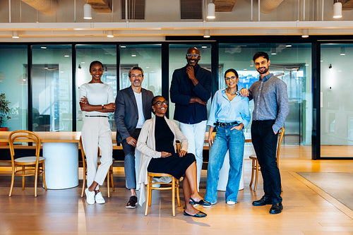 Group of diverse individuals smiling together in a stylish office setting