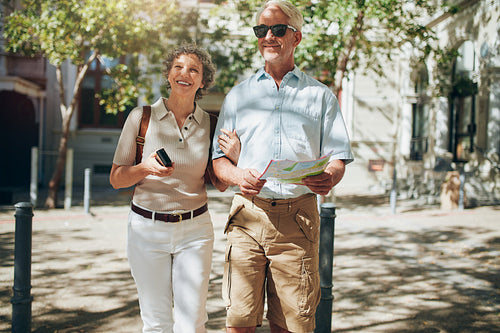 Senior couple walking around the city holding a map