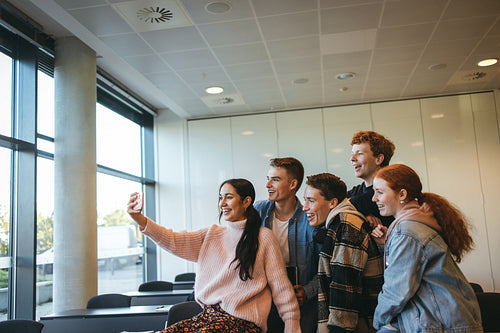 Friends in a classroom taking group selfie
