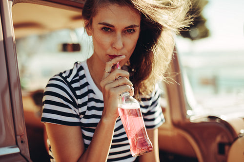 Woman drinking beverage on road trip
