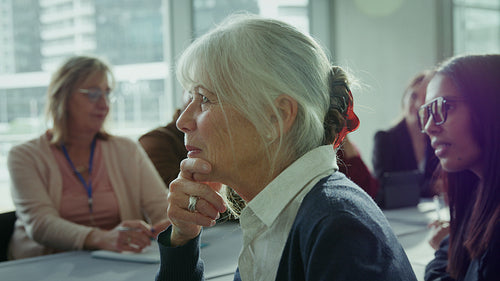 Senior woman smiles during business meeting