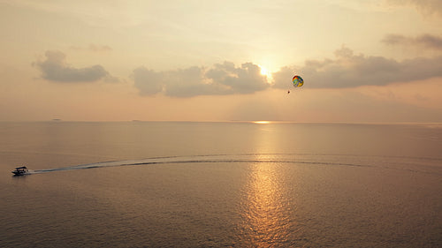 Parasailing over the vast ocean during a stunning sunset