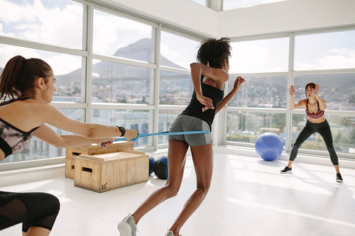 Woman working out at gym with personal trainers