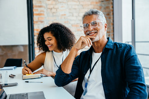 Smiling colleagues collaborate effectively in a modern office, showcasing teamwork and productivity in a diverse work environment