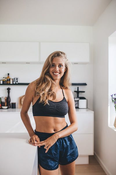 Smiling young woman standing relaxed in kitchen