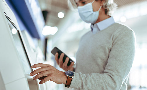 Man making self check in at airport during pandemic
