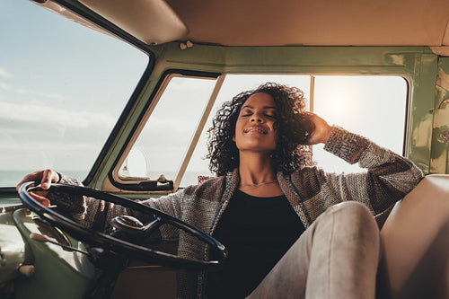 Woman on road trip taking rest in the van