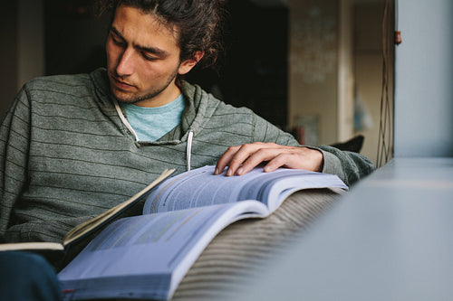Man writing in book sitting at home