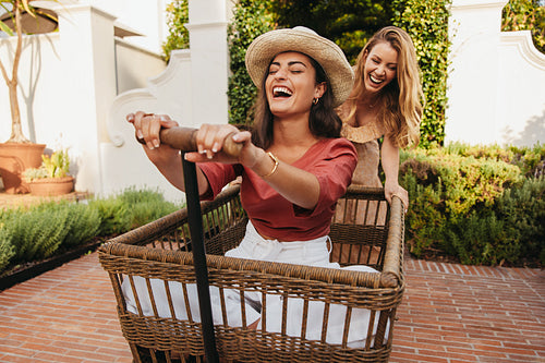 Female friends having fun with a trolley cart
