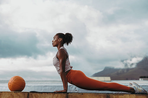 Sportswoman doing cobra pose yoga on rooftop