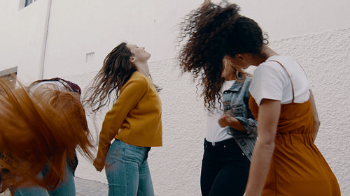 Friends dancing and blowing confetti outdoors